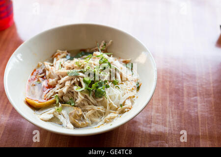 Ciotola di tagliatelle con le verdure sul tavolo di legno. Deliziosi noodle. calda e acida zuppa tailandese originale cibo. Tom Yum Foto Stock