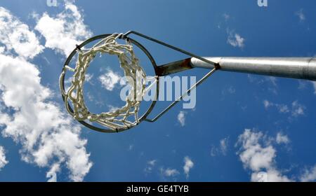 Prospettiva astratta di un cerchio di netball con net contro un cielo blu e Sfondo nuvola. Foto Stock