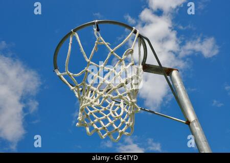 Prospettiva astratta di un cerchio di netball con net contro un cielo blu e Sfondo nuvola. Foto Stock
