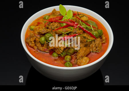 Rosso tailandese curry di manzo nella ciotola bianco su sfondo nero Foto Stock