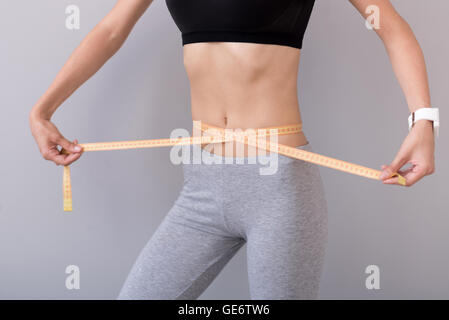 Slim donna con nastro di misurazione Foto Stock