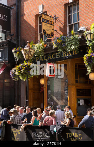 Irlanda, Dublino, Temple Bar, Fleet Street, il Palace Bar, i clienti nella luce del sole su pavimentazione Foto Stock