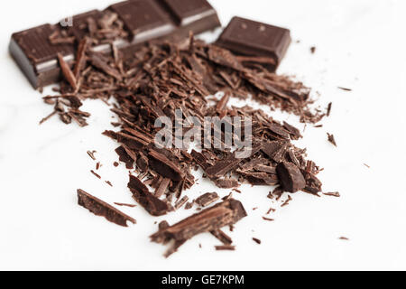 Barra di cioccolato e trucioli su sfondo bianco Foto Stock