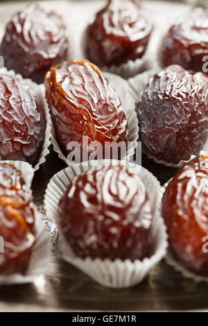 Medjool date in casi di cioccolato su un vassoio Foto Stock