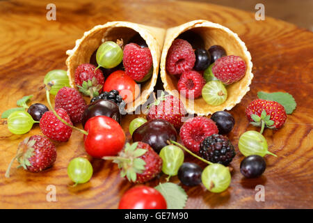 Varie freschi frutti di bosco organico nel cono di cialda di gelato Foto Stock