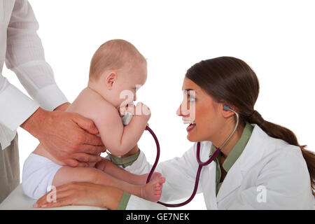 Una foto di una femmina di pediatra esaminando baby boy tenuto da padre medico controllo toddler con uno stetoscopio Foto Stock