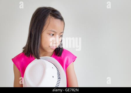 Adorabili e felici i bambini asiatici in un abito rosa con cappello bianco. Foto Stock