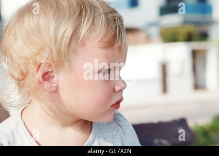 Outdoor close up ritratto di profilo di gravi carino bionda caucasica Baby girl Foto Stock