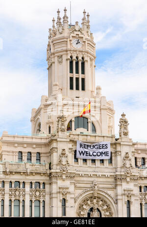 I rifugiati Benvenuti poster drappeggiati in tutta la facciata del Palacio de Cibeles, ora casa di Madrid City Hall, Madrid, Spagna Foto Stock