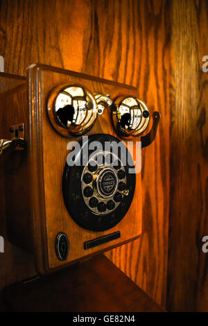 Un moody e nostalgico vista dentro un vintage pagare in legno cabina telefonica Foto Stock