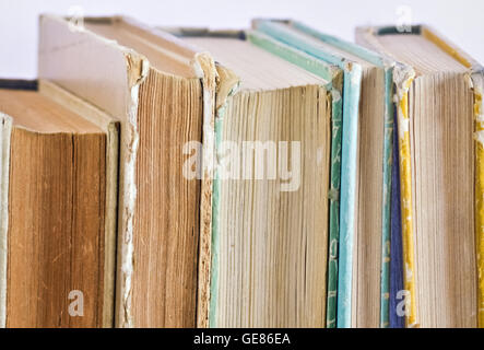 Primo piano di diversi libri antichi collocati verticalmente sul ripiano Foto Stock