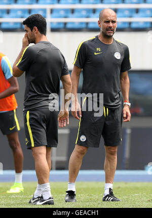 Pechino, Cina. Il 24 luglio, 2016. Pep Guardiola (R), il manager del Manchester City parla con il membro del team, ex arsenale lettore di Mikel ARTETA durante la sessione di formazione per la partita contro il Manchester United FC del 2016 International Champions Cup in Cina il torneo di calcio a Olympic Sports Center Stadium di Pechino, Cina, il 24 luglio 2016. Il derby si terrà presso lo stadio nazionale, o il Bird's Nest, lunedì. Credito: Xinhua/Alamy Live News Foto Stock