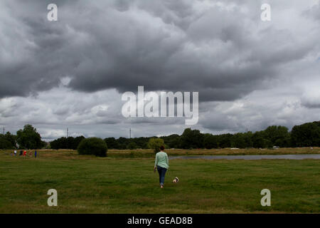 Wimbledon Londra,UK. Il 24 luglio 2016. La gente a piedi sotto le nuvole scure in Wimbledon Common come il tempo fresco a Londra è prevista la prossima settimana a seguito di una ondata di caldo e di temperature elevate Credito: amer ghazzal/Alamy Live News Foto Stock