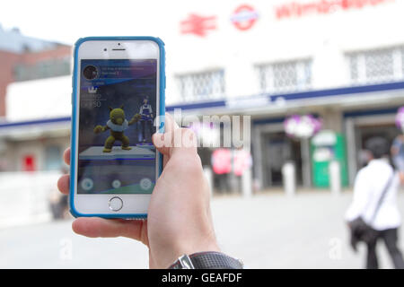 Il torneo di Wimbledon di Londra, Regno Unito. Il 24 luglio 2016. Pokemon gli appassionati di gioco di assemblaggio con i loro dispositivi smartphone Wimbledon in centro città per la cattura di Pokemons come Pokemon mania spazza il paese Credito: amer ghazzal/Alamy Live News Foto Stock