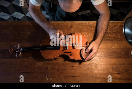 Liutaio regolazione del suono post di un violino nel suo laboratorio Foto Stock