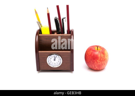 Tavolo in legno set di cancelleria con Apple su uno sfondo bianco isolato. Foto Stock