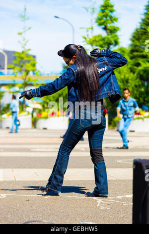 Parte posteriore della femmina di rockabilly ballerino in piena jean vestito e vintage pettinatura a ballare il rock and roll music weekly a Yoyogi Park Foto Stock