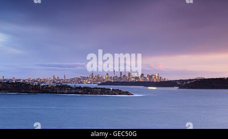 Panorama sul porto di Sydney entrata dietro la testa del sud con il faro e il CBD di città in background distanti al tramonto Foto Stock