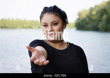 Giovane donna asiatica raggiungendo fuori Foto Stock