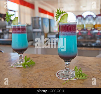 Coppia di blu ornato cocktail bevande con limone e menta su marmo bar bancone Foto Stock