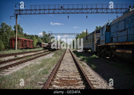 Decadendo treni e binari all'interno di Chernobyl zona di esclusione, Ucraina. Foto Stock