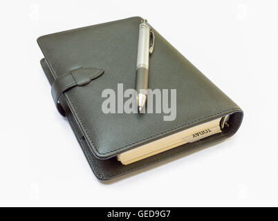Notebook in pelle e penna in uno sfondo bianco Foto Stock