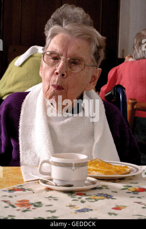 Senior Citizen gustando il tè del pomeriggio a una pensione di vecchiaia home Foto Stock