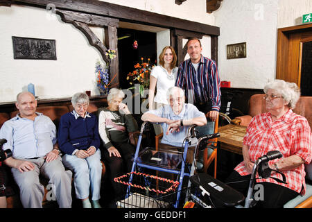 Residenti e personale infermieristico in sala comune di una casa di cura Foto Stock