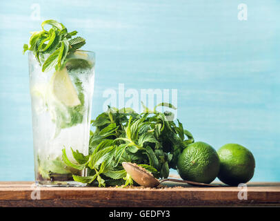 In casa cocktail mojito nel bicchiere alto con mazzetto di menta, lo zucchero di canna e limes Foto Stock