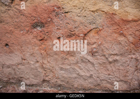 Roccia grezza texture di sfondo con arancia e lievi tinte di rosa Foto Stock