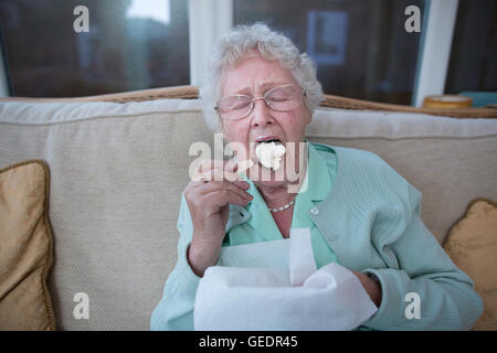 La vecchiaia pensionato godendo di un gelato mentre vivono da soli in Inghilterra, Regno Unito Foto Stock