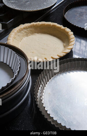 Base di pastafrolla per torta in padella Vicino altro vuoto pentole a torta Foto Stock