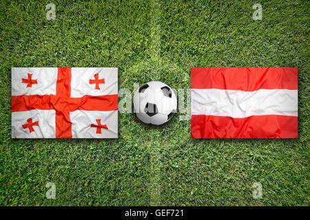 La Georgia vs. Austria bandiere sul verde del campo di calcio Foto Stock