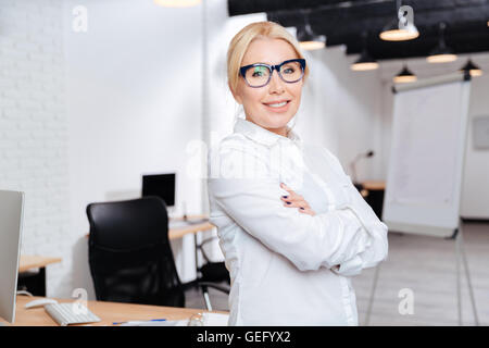 Ritratto di un allegro coppia business donna in piedi con le braccia piegate in ufficio Foto Stock