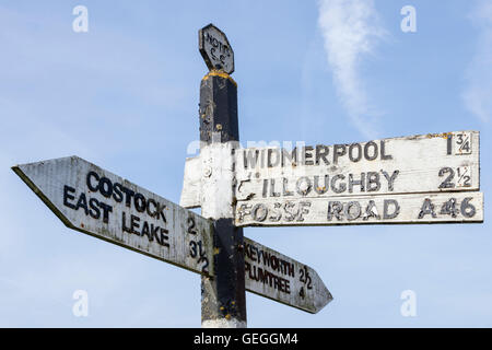 In legno antico cartello stradale che mostrano la direzione, la destinazione e la distanza per frazioni di Nottinghamshire, England, Regno Unito Foto Stock