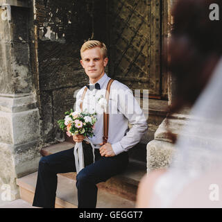 Sposa seduta sui gradini di pietra Foto Stock