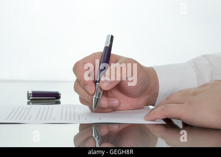 Mano con la penna sul modulo di domanda, imprenditore firma un contratto con il concetto di penna a sfera. Foto Stock