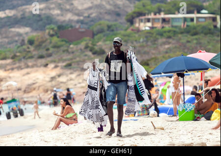 Uomo nero che vendono vestiti a Santa Margherita di Pula spiaggia in Sardegna, Italia Foto Stock