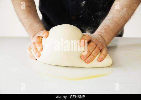 Close up di un fornaio impastare e sagomatura di un grande di pasta di pane. Foto Stock