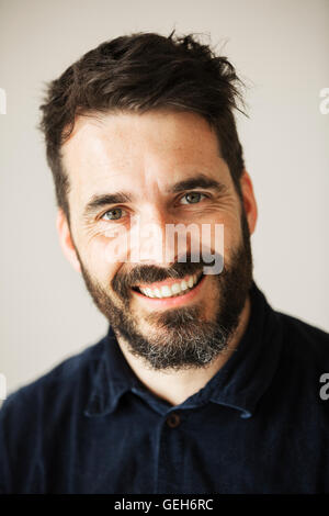 Ritratto di un uomo barbuto sorridente alla fotocamera. Foto Stock