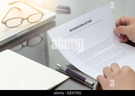 Imprenditore rivedere le sue dimissioni lettera sulla sua scrivania prima di inviare a suo boss per abbandonare il suo lavoro. Lettera di dimissioni informazioni Foto Stock