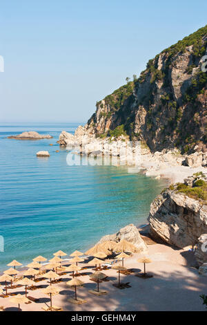 Bellissima spiaggia in Montenegro con ombrelloni di paglia in mattina presto Foto Stock