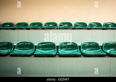 Due righe di vuoto sedili verde in una sala sportiva Foto Stock