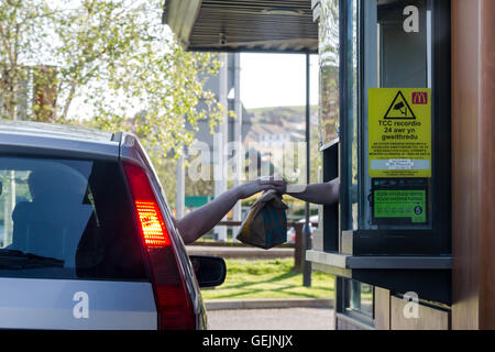 Il personale passando il cibo oltre al cliente a un Mc Donald's ristorante fast food Foto Stock