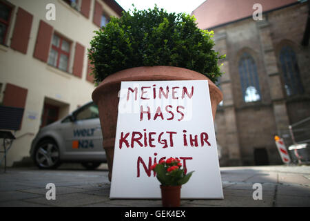 Ansbach, Germania. 26 Luglio, 2016. I fiori sono state poste prima di un cartello con la scritta "Non puoi ottenere il mio odio' nella Città Vecchia di Ansbach, Germania, 26 luglio 2016. 15 persone sono rimaste ferite in un islamista sospetti motivati attaccare il 24 luglio 2016. Il sospettato colpevole, un 27-anno-vecchio rifugiato dalla Siria, è stato ucciso nell'esplosione. Foto: DANIEL KARMANN/dpa/Alamy Live News Foto Stock