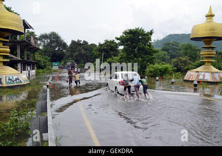 Nagaon, Assam, India. 27 Luglio, 2016. Veicolo e persone attraversano sommerso National Highway 37 a causa di una forte alluvione in Bagori Village vicino al Parco Nazionale di Kaziranga ,circa 200 km di distanza da Guwahati, la città capitale del nord-est dello stato indiano Assam mercoledì. Il rapido aumento dell'acqua di allagamento ha causato una perdita per la vita e la proprietà in Assam. Credito: DIGANTA TALUKDAR/Alamy Live News Foto Stock