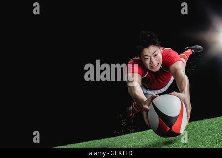 Ritratto di giapponese giocatore di rugby immersioni il cliente a provare Foto Stock