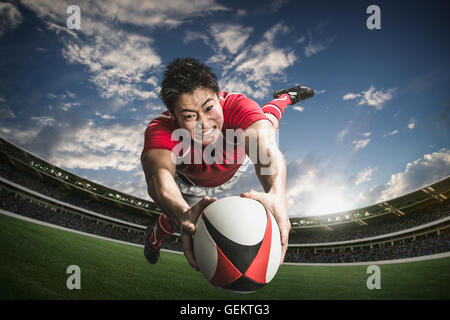 Ritratto di giapponese giocatore di rugby immersioni il cliente a provare Foto Stock