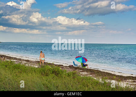 Florida Keys, Bahia Honda State Park, praterie sulla spiaggia, ombrellone, donna bikini Foto Stock
