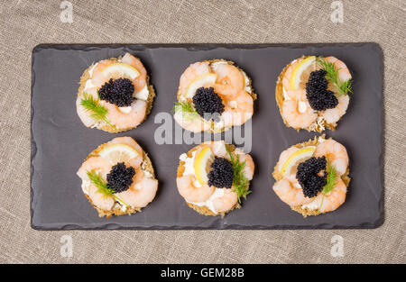 Antipasto di gamberetti servita su fette di pane tostato e servite su un piatto di ardesia Foto Stock
